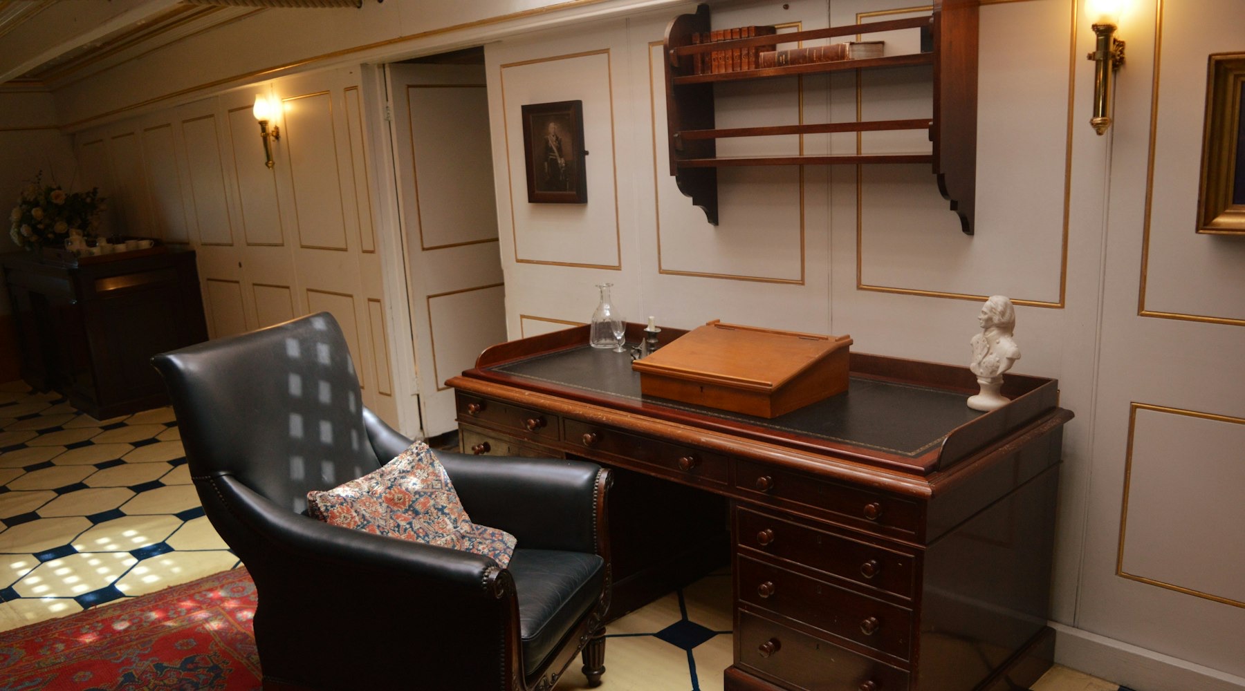 A quiet panelled study with a writing desk and leather armchair