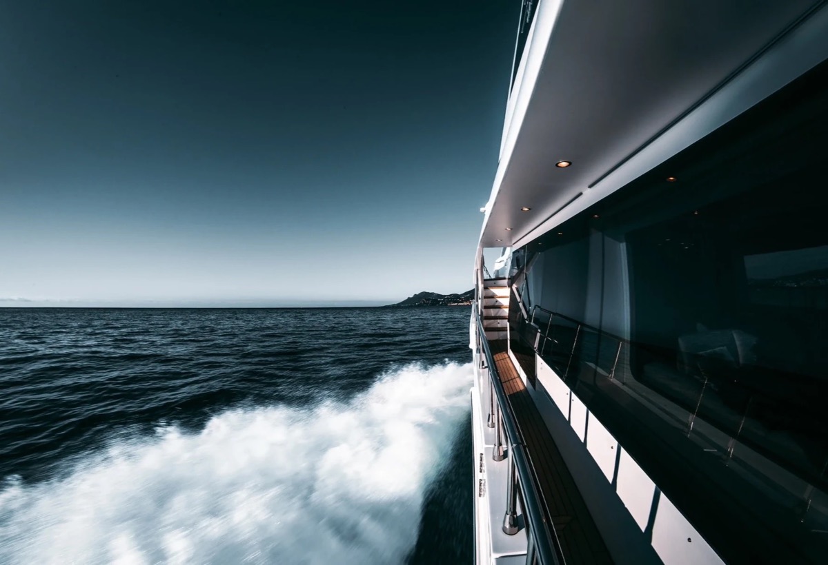 A motor yacht underway on open water at dusk