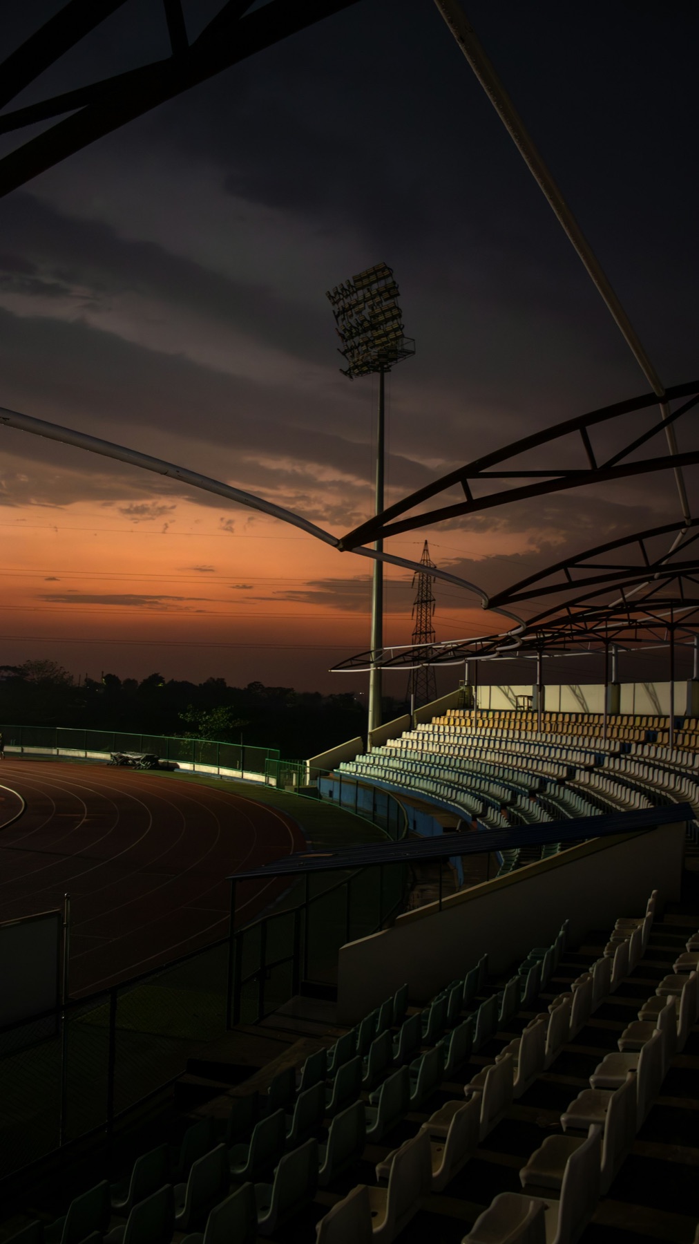 A stadium silhouetted against a dusk sky